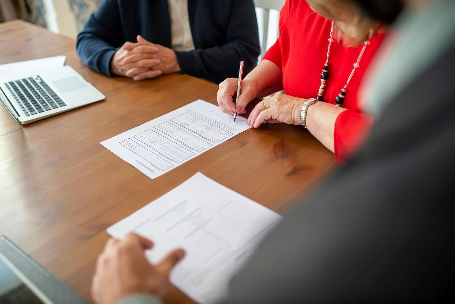 woman signing a contract in an office in the presence of lawyers 8439700 scaled